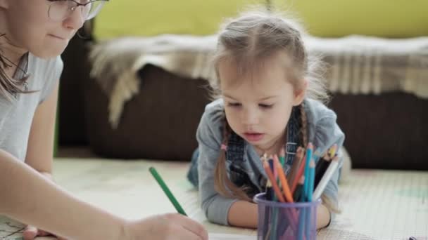 真正的两个快乐的孩子，带着妈妈画铅笔，春天来了，照片彩虹在室内游戏室的地板上玩得很开心。童年、艺术、教育、创造力、动机概念 — 图库视频影像