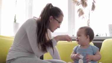 Yeni doğmuş beyaz bir annenin sabahları kucağında tuttuğu ve yeni doğan bebeği okşadığı otantik yakın plan çekimleri. bebek, annelik, annelik, ebeveynlik, çocukluk, yaşam, özgünlük kavramı