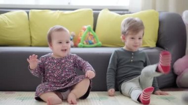 Otantik İki kardeş, çocuklar, erkek kardeşler ve kız kardeşler, evlerinde paspas zemine basan duygu jestlerini göstererek eğlenirler. bebek, arkadaşlık, aile, çocukluk, hayat, özgünlük