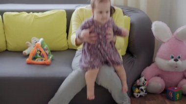 Beyaz tenli genç annenin otantik yakın çekimi kollarını tutar, evde yeni doğmuş bebeği okşarken aktif egzersiz yapar. bebek, annelik, annelik, çocukluk, aile, özgünlük kavramı