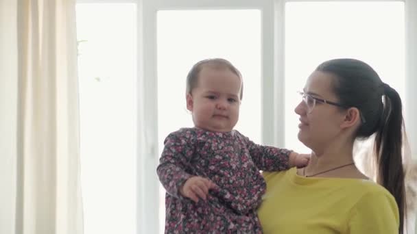 Slo-mo Authentic menutup ibu muda neo-Kaukasia bermain dengan bayi perempuan bayi bersenang-senang menghabiskan waktu di dalam rumah. Wanita muda menenangkan anak menangis. Keibuan, masa kecil, keluarga, konsep gaya hidup — Stok Video