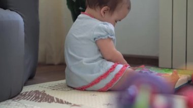 Burnu sümüklü, şirin, tombul kız çocuğu renk oyuncağı yap-bozunu yakınlaştırıyor. Küçük çocuk oyun odasında motor becerileri için tek başına eğitim oyunları oynuyor. Çocukluk, aile, yalıtım konsepti