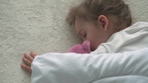 Authentique gros plan de mignon caucasien petit enfant d'âge préscolaire fille 3-4 ans dormir doucement dans un lit blanc confortable avec ours en peluche. Garde d'enfants, Bébé au lit, Enfance, Parentalité, concept de vie — Video