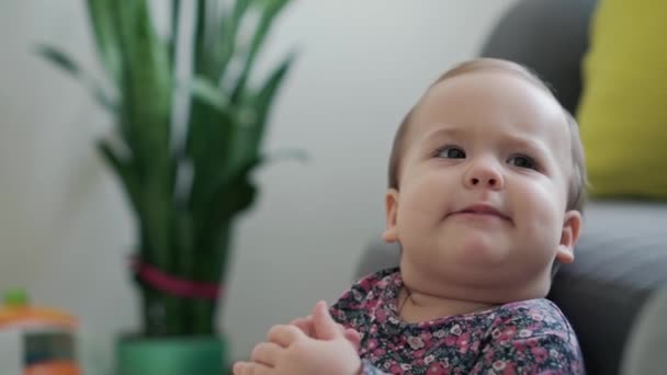 Authentic close up shot happy little infant chubby girl plays with foot and pulls her toes into her mouth. baby have fun spend time at home indoors. motherhood, childhood, family, authenticity concept — Stock Video