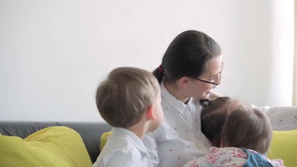 Kaukasiska familj små barn flicka pojke och mamma talar i videokonferens via smartphone tillsammans i vardagsrummet hemma med glädje leende. aktivitetsteknik livsstil mobiltelefon användning koncept — Stockvideo