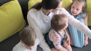 Kafkas ailesi küçük çocukları kız çocuk ve anne akıllı telefonlarıyla video konferansında evdeki oturma odasında mutluluk gülümsemesiyle sohbet ediyorlar. faaliyet teknolojisi yaşam tarzı cep telefonu kullanımı kavramı