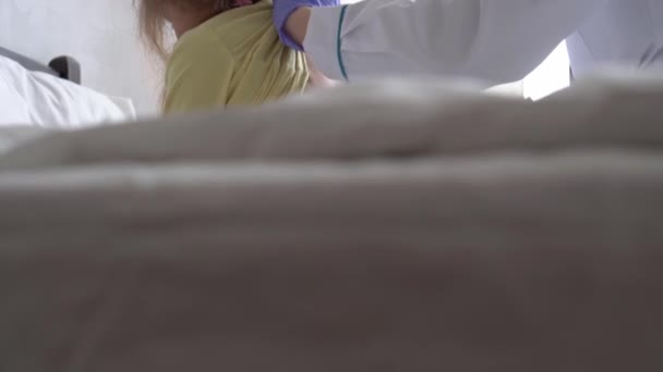 Autentikus aranyos kaukázusi aranyos fiatal nő nővér vagy orvos gyermekorvos megvizsgálja statoszkóp kisebb óvodás kislány gyerek fehér ágy a kórházban. orvostudomány és egészség, gyermekgyógyászat, covid-19 koncepció — Stock videók