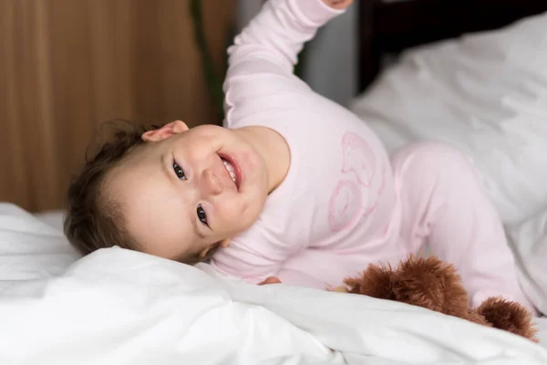 진품화 된 초상화는 하얀 침대에서 웃고 있는 귀여운 곰 인형을 보면서 잠에서 깨어난 미소를 짓고 있는 백색광의 어린 아기 아기나 소년에게 영향을 준다. 자녀 양육, 어린 시절, 부모로서의 역할, 생활 개념 — 스톡 사진