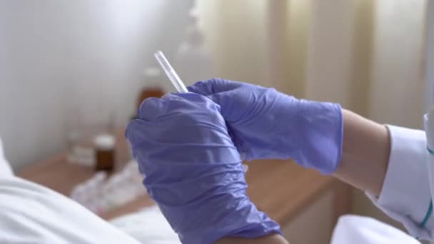 Закрытие рук женщины-врача или медсестры в синих защитных перчатках вытягивает вакцину из ампулы в шприц в больничном кабинете. медицинский осмотр и вакцинация. Медицина и здоровье, концепция covid-19. — стоковое видео