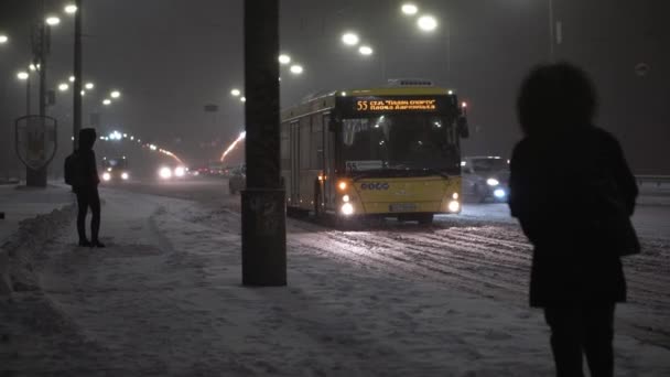 Kiev, Oekraïne: 2021.02.23 - Geweldige sneeuwval 's nachts stadsweg op lantaarn achtergrond vroege winter. Mensen haasten zich naar huis op kerstavond. Weer, Natuurverschijnselen, Oud en Nieuw, Stedelijk vervoer — Stockvideo