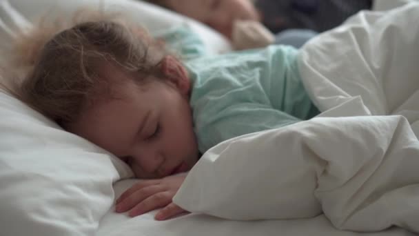 Autentický portrét roztomilé kavkazské malé předškolní sourozence chlapeček a dívka v modrém spánku s medvídkem na bílé posteli. dítě odpočívající v poledne. péče, medicína a zdraví, Dětství, životní koncept — Stock video