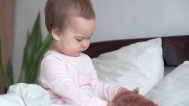 Otantik beyaz portre, pembe uykulu küçük tombul kız bebek ya da beyaz yatakta tatlı tatlı gülümseyen ve somurtan kameraya bakarak uyanan oğlan. Çocuk bakımı, Çocukluk, Ebeveynlik, hayat konsepti