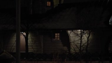 Gece parkında inanılmaz bir kar yağışı var. Arka planda fener var. Eski Rus ahşap kilise tapınağı tepsisinin yanında. Meteoroloji, Hava Durumu, Doğal Fenomen, Mutlu Noeller ve Yeni Yıl Konsepti