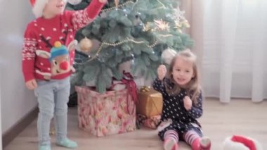 Süslü Noel ağacının yanında maytaplı neşeli çocuklar birlikte iyi eğlenceler. Anaokulundaki küçük bebek evde yeni yılı kutluyor. Kış, tatil, aile kavramı