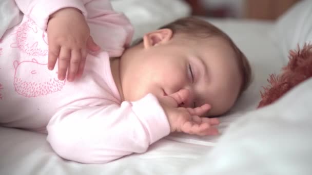 Autentico ritratto carino caucasico neonato paffuto bambina o ragazzo nel sonno rosa con orsacchiotto sul letto bianco. bambino che riposa all'ora di pranzo. cura, Bambino che dorme, Infanzia, Genitorialità, concetto di vita — Video Stock