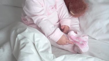 Otantik beyaz portre, pembe uykulu küçük tombul kız bebek ya da beyaz yatakta tatlı tatlı gülümseyen ve somurtan kameraya bakarak uyanan oğlan. Çocuk bakımı, Çocukluk, Ebeveynlik, hayat konsepti
