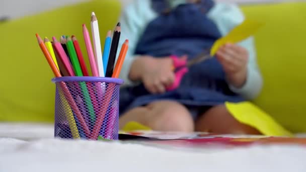 Pendidikan seni pembelajaran online - Salah satu preshool kreatif, gadis balita membuat kerajinan memotong kertas berwarna dengan gunting duduk di atas meja. bayi kecil bahagia anak di karantina di rumah, motilitas tangan — Stok Video