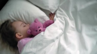 Üst düzey, otantik, beyaz, beyaz, anaokulu erkek kardeşleri, mavi pijamalı kız ve erkek çocukları beyaz yatakta oyuncak ayıyla uyurlar. çocuk istirahati, bakım, ilaç ve sağlık, çocukluk, yaşam konsepti