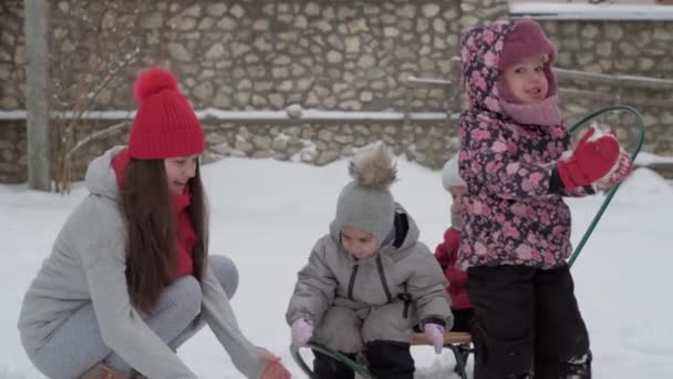 Nyaralás, játék, családi koncepció - slo-mo hiteles 3 boldog óvodás kisgyerek testvérek fiatal wonan anya sok gyermek hányni hó. hóesés hideg évszakban időjárás télen udvaron — Stock videók
