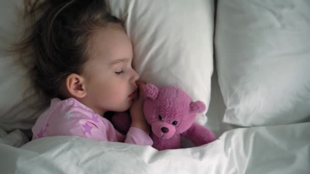 Vista superior auténtico lindo caucásico pequeños hermanos preescolares bebé y niña en pijamas de color rosa azul dormir con oso de peluche en la cama blanca. descanso infantil, cuidado, medicina y salud, Infancia, concepto de vida — Vídeo de stock