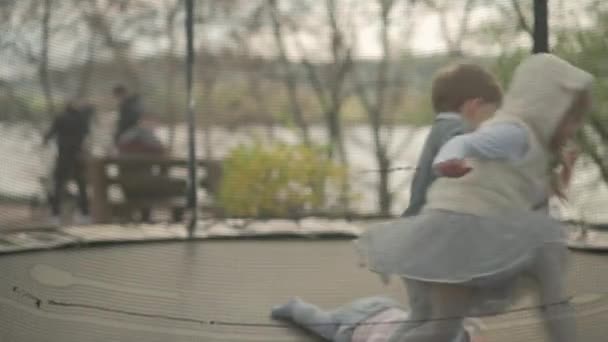 Lente, Sport, Vakantie, Familie, Jeugd - Slow motion Drie vrolijke peuter kleuter kleuterschool broers en zussen Kinderen tweeling kinderen spelen plezier springen ballen op trampoline buiten zonnige avond zonsondergang in park — Stockvideo