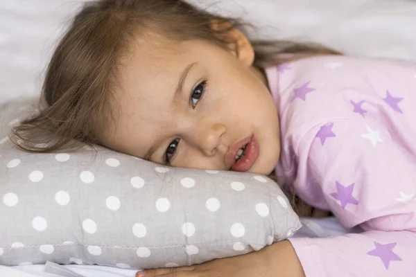 Zuhause, Trost, Kindheit, Schlaflosigkeit, Schlaflosigkeit, süßer Traum - kleine traurige authentische Kleinkind Geschwisterkind Kind Mädchen im Schlafanzug liegen Ruhe kippen Schlaf auf Bettkissen mit offenen Augen weiche gemütliche schläfrige Stimmung — Stockfoto