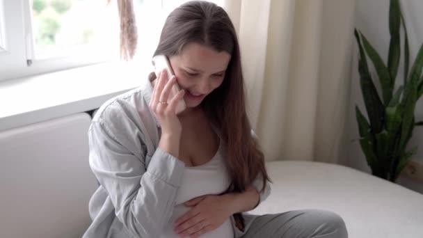 Szczęśliwa kobieta w ciąży z tabletem mieć połączenie wideo za pomocą smartfona komunikuje się z mężem za pośrednictwem czatu konsultacji online z lekarzem porozmawiać z przyjaciółmi na telefon komórkowy. ciąża, technologia, medycyna — Wideo stockowe