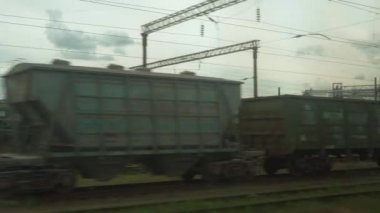 Yüksek hızlı tren penceresinden, paslı vagonların ve yüksek tuğlalı bacaların manzarasından yaz arkaplanındaki bulutlu güzel gökyüzünün manzarasına. Ulaşım, seyahat, demiryolu, yol, zina kavramı