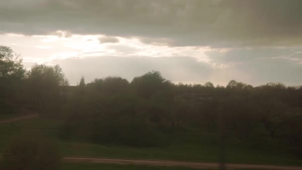 Blick aus dem Fenster des Hochgeschwindigkeitszuges auf Landschaft der schönen Natur Feldweg mit Auto und Wald am Abend Abendhimmel Sonnenuntergang im Sommer Hintergrund. Verkehr, Reisen, Bahn, Kommunikationskonzept — Stockvideo