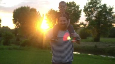 Yaz, tatil, doğa, mutlu aile, çocukluk, babalık günü - Anaokulu çocuk babasıyla çocuk uçağa binip kanat çırpmaca oynuyor. İyi eğlenceler.