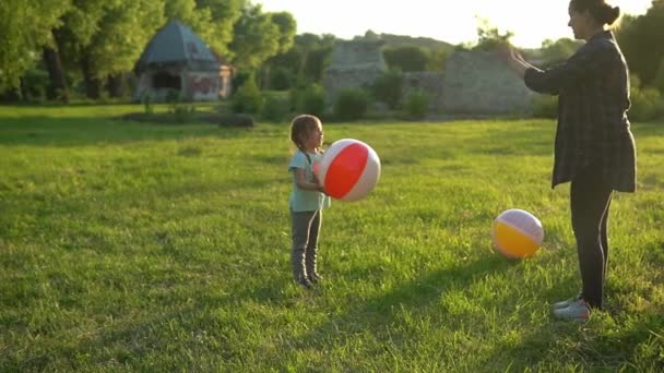 Lato, natura, szczęśliwa rodzina, ciąża, Dzień Matki - ciężarna mama z dwójką dzieci bawiących się w gry z dużą piłką w parku o zachodzie słońca. Szczęśliwy uśmiech Dzieci baw się dobrze, śmiej się spędzać czas razem — Wideo stockowe