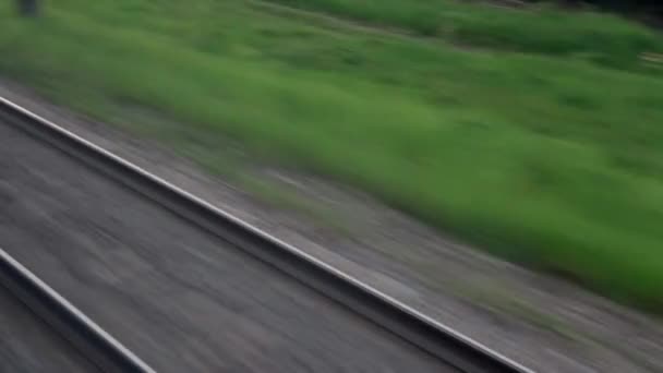 Θέα από το παράθυρο του τρένου ταχύτητας με λάμψη σε γυαλί και παράλληλες ράγες στο τοπίο των λιβαδιών και των δασών πριν από τη δύση του ηλίου το καλοκαίρι φόντο. Μεταφορές, ταξίδια, οδικές, σιδηροδρομικές, έννοια της συνουσίας — Αρχείο Βίντεο
