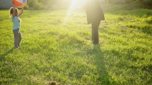 Verano, naturaleza, familia feliz, embarazo, día de la madre - madre embarazada con dos niños pequeños jugando juegos con pelota grande en el parque al atardecer. Feliz sonrisa Los niños se divierten, se ríen pasan tiempo juntos — Vídeo de stock