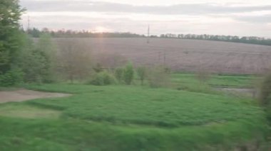 Ulaşım, seyahat, yol, demiryolu, manzara, yakınlaşma konsepti - yazın günbatımından önce gün batımından önce araba ve ormanla birlikte güzel doğa yolu manzarası üzerinde hız treninin penceresinden manzara