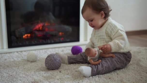 Baby spelen met kat. tomcat op tapijt in de buurt van brandende open haard thuis comfort. gestreept kitten spelen met bal van draad. Kitty loopt naar de camera te kijken. gelukkig schattig huisdier, kindertijd, wild natuur concept — Stockvideo