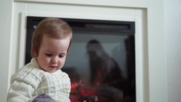 Baby spelen met kat. tomcat op tapijt in de buurt van brandende open haard thuis comfort. gestreept kitten spelen met bal van draad. Kitty loopt naar de camera te kijken. gelukkig schattig huisdier, kindertijd, wild natuur concept — Stockvideo