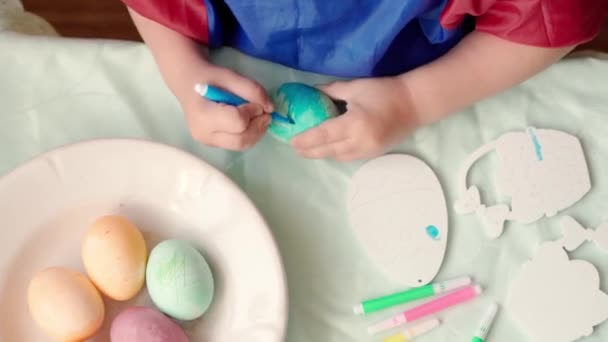 С праздником Пасхи. Красивые дети красят яйцо для традиционного весеннего ужина дома. Девочка и мальчик играют в дурака, рисуя пасхальные яйца. Детство, образование, праздничная концепция — стоковое видео