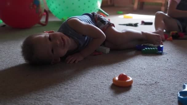 Fratellini prescolastici bambini seduti sul pavimento con giocattoli in camera dei bambini. I ragazzi stanno giocando con il costruttore in sala giochi. i bambini hanno trascorso del tempo divertente a casa. Infanzia, amicizia, concetto di sviluppo — Video Stock