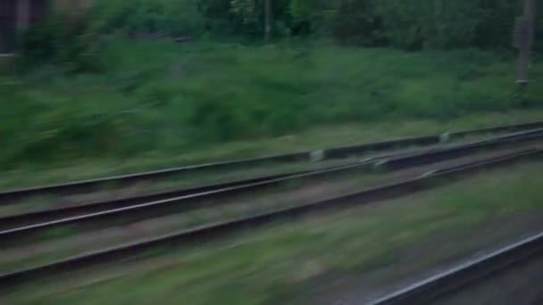 从高速列车窗口眺望美丽的自然风光、田野、村舍和森林，暮色黄昏的天空在夏夜的背景下落幕。运输、旅行、铁路、通信概念 — 图库视频影像