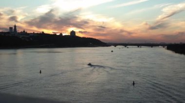 Top Aerial Manzaralı Renkli Yaz Gökyüzü. Gün batımında Dnipro nehrinde balıkçıyla motorlu tekne gezintisi. Kiev Ukrayna 'daki göllerin üzerindeki köprü manzarası. Su taşımacılığı, seyahat