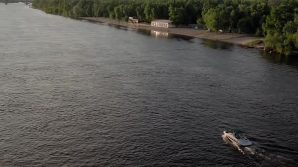 Вид сверху на движущийся океан рыболовной лодки. парусная моторная лодка с рыбаком на Днепре на закате. ландшафт моста через озера в городе. водный транспорт, путешествия, лето, отдых, водохранилища — стоковое видео