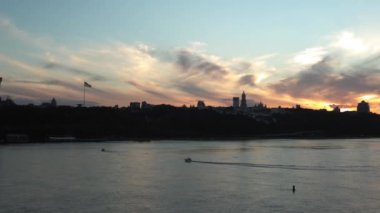 Top Aerial Manzaralı Renkli Yaz Gökyüzü. Gün batımında Dnipro nehrinde balıkçıyla motorlu tekne gezintisi. Kiev Ukrayna 'daki göllerin üzerindeki köprü manzarası. Su taşımacılığı, seyahat