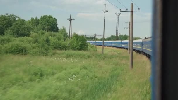 Widok boczny kolei dużych prędkości pociągu na krajobraz pięknej przyrody dzikie pole i las na wieczór zachmurzone zmierzch niebo zachód słońca w tle lata. Transport, podróże, kolej, koncepcja komunikacji — Wideo stockowe