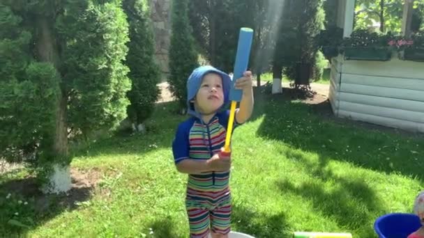 Carino bambino felice bambina prescolare e bambino bambino giocare divertirsi con pistola pompa ad acqua all'esterno. Sunny Hot Bella giornata a Park. Giochi di Giardino di cortile da bambini. Estate, Sport, Vacanza, Famiglia, Infanzia — Video Stock