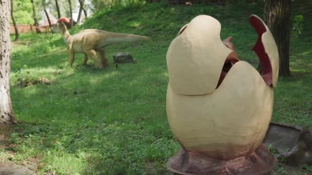 2021.08.12 - Kiev, Ukraine: Motorized Dinosaur hatches from egg Predator Mamenchisaurus Mockup in Amusement Forest Park. Exhibition of Moving Model Animals from Jurassic Prehistoric Period in Dinopark — Stock Video