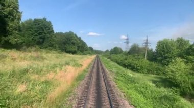 Yüksek hızlı dönüşün mavi yanlı manzarası trenin arka tarafında güzel doğa manzarası vahşi arazi ve dağların ormanı yaz aylarında güneşli bir günde. Ulaşım, seyahat, demiryolu, iletişim