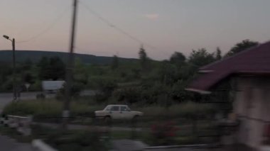 Yüksek hızlı trenden doğa arazisi ve ormanın manzarasına akşamüstü alacakaranlık gökyüzü günbatımı yaz arkaplanında. Kırmızı batan güneş ufukta. Ulaşım, seyahat, demiryolu, iletişim konsepti