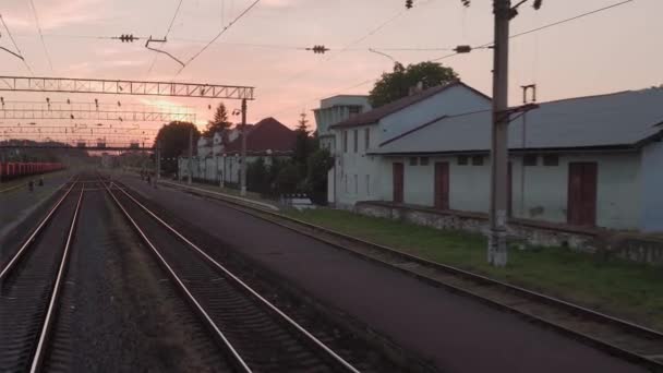 Vista desde la ventana tren de alta velocidad en el paisaje de la hermosa naturaleza salvaje campo y vías del ferrocarril forestal carriles en la puesta de sol de la noche en el fondo de verano. Transporte, viajes, ferrocarril, concepto de comunicación — Vídeos de Stock