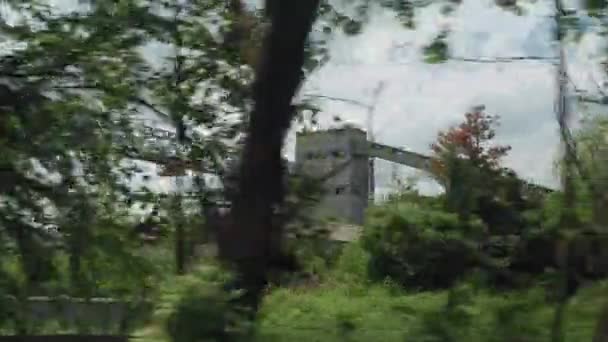 Vista desde la ventana del tren de alta velocidad en el paisaje de la zona industrial antigua planta soviética y el bosque en el día soleado limpio nublado en el fondo de verano. Transporte, viajes, ferrocarril, concepto de comunicación — Vídeo de stock