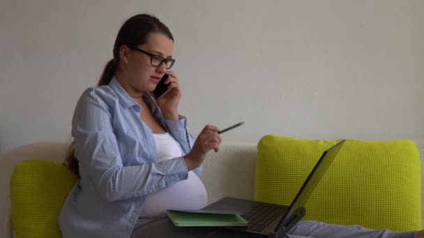 Femme d'affaires enceinte qui travaille dur avec succès avec ordinateur portable. Young Ledy In Pregnancy parle appel par téléphone Documents de travail Utilisation à distance d'Internet et de la technologie en ligne à la maison. Congé de maternité Concept — Video